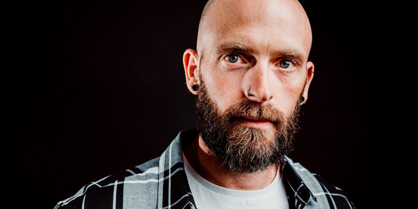 Young bald guy on black background